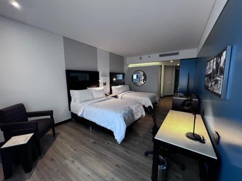 波哥大波哥大机场假日酒店的酒店客房,配有两张床和椅子