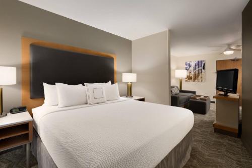 凤凰城凤凰城北春季山丘套房酒店的一张大白色的床,位于酒店客房内