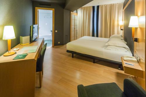 巴塞罗那巴塞罗那环球酒店的一间卧室配有一张床和一张带电脑的书桌