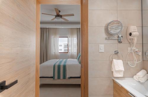 蓬塔卡纳Lujoso apartamento con piscina cerca de la playa的配有床和吊扇的浴室