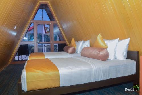 KilinochchiReecha Organic Resort Jaffna的带窗户的客房内的两张床