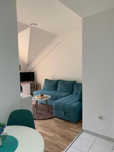 马夫罗沃Filip Apartment的客厅配有蓝色的沙发和桌子