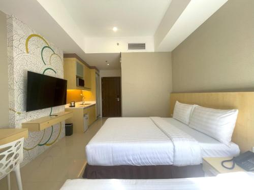 马尼拉Hotel101 - Fort的配有一张床和一台平面电视的酒店客房