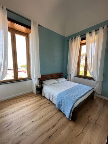 托雷德尔格雷科Villa Mazza al Vesuvio的一间卧室设有一张床和两个窗户。