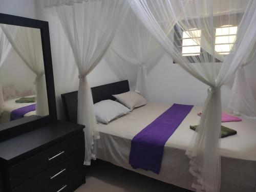 KamburugamuwaRed Rose Villa Mirissa的一间卧室配有两张床、窗帘和镜子