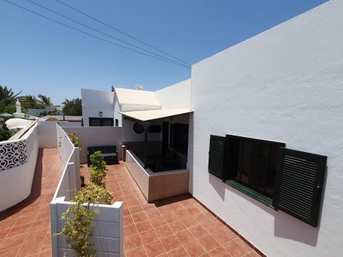 特吉塞Casa El Eco del Volcán 1的白色的房子,设有种有盆栽植物的庭院