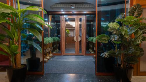 卡尔斯GRAND ANİ HOTEL的走廊上设有盆栽和开放式门