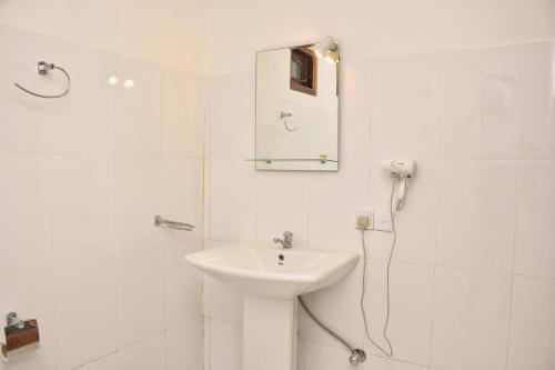 锡吉里亚Sunrise Cottage的白色的浴室设有水槽和淋浴。