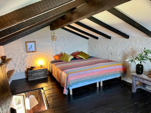 卡尔热斯charmante bergerie à Cargese tres belle vue mer avec jardin的一间卧室配有一张带彩色条纹毯子的床