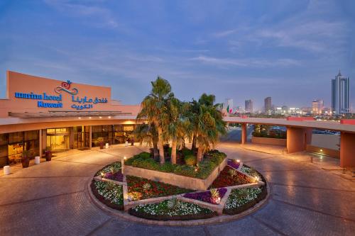 科威特萨佛酒店的一座建筑前有棕榈树的商场