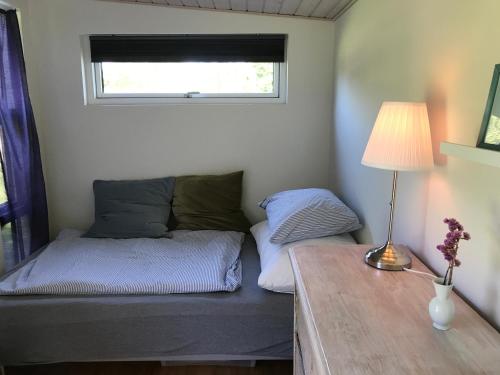 瓦伊比Cutest annex - close to Heatherhill and sea :-)的一间卧室配有一张床和一张带台灯的桌子