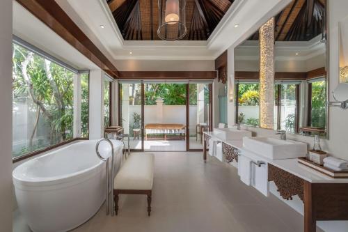 努沙杜瓦巴厘岛努萨杜瓦拉古纳豪华假日温泉酒店的一间带两个盥洗盆和大浴缸的浴室