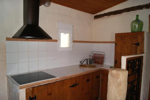 阿尔卡拉斯Casas Rurales Los Cortijos的一间带水槽和炉灶的小厨房