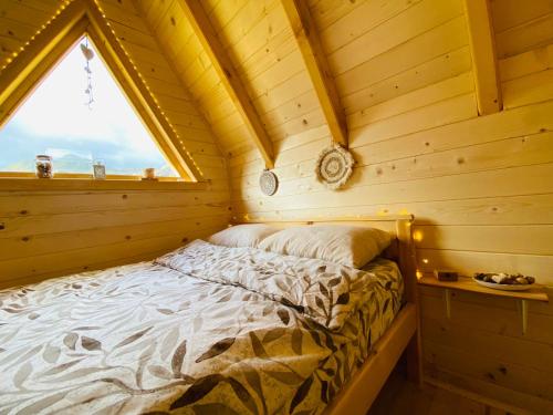 波德戈里察Kapetanovo Jezero Bungalov的小木屋内的一张床位,设有窗户