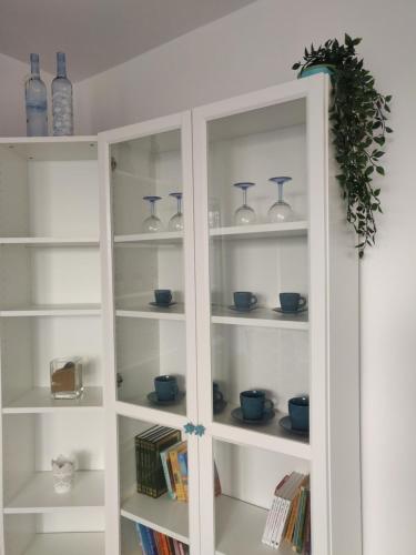 格丁尼亚Płyta 129的白色书架,上面有蓝色花瓶和书籍