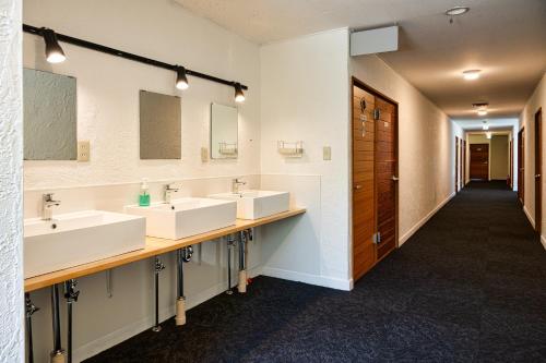 茅野Hütte Jil Shirakabako的浴室设有3个水槽和2面镜子
