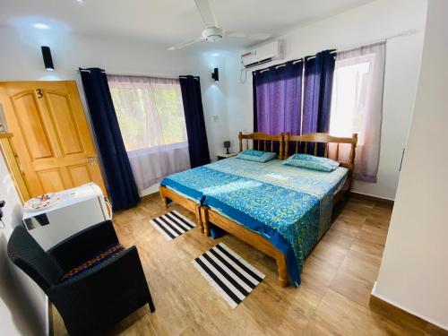 博瓦隆Oceanic View Apartments的一间卧室配有一张床、一把椅子和窗户。