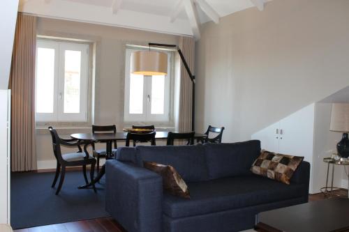 波尔图波尔图历史公寓的客厅配有蓝色的沙发和桌子