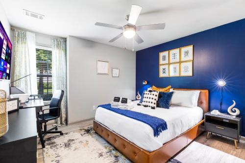 亚特兰大Modern Swank Luxury Aptmins The Battery3bd2br的一间卧室设有蓝色的墙壁和一张带书桌的床。