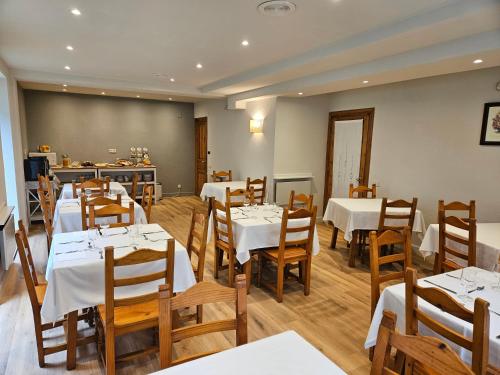 维耶拉安格拉达酒店的用餐室配有白色的桌子和木椅