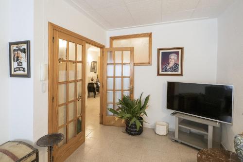 皮内达德马尔L'Hostalet GuestHouse的客厅配有平面电视和平面电视。