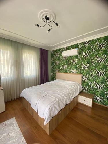 费特希耶2+1 Merkezi Konumda Doublex Daire No:2的一间卧室配有一张带绿色墙壁的床