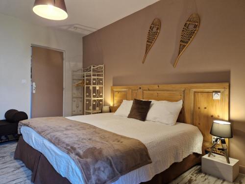PupillinUNE AUTRE MAISON Chambres d'hôtes的一间卧室配有一张大床和木制床头板