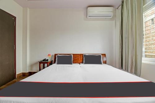 BhutiāgāonCollection O The Grand Megha Resort的卧室配有一张大白色床和窗户