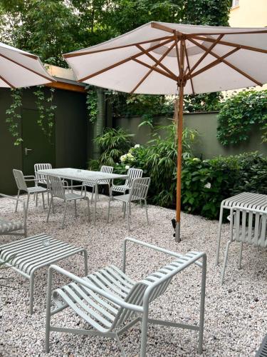 柏林ADELANTE Boutique Hotel的庭院内桌椅和遮阳伞
