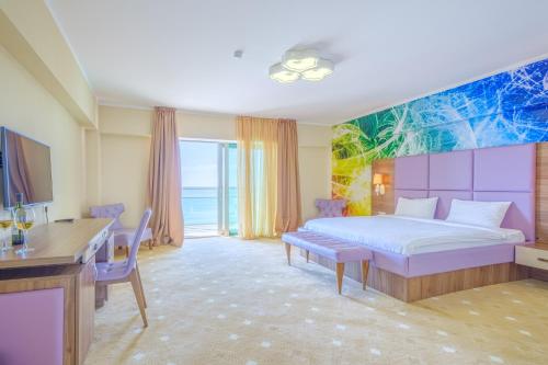 巴统Castello Mare All Inclusive Resort的一间卧室配有一张床、一张桌子和一张书桌
