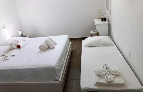 KrotiriSweet Home Nikorenia 1的一间卧室配有两张带毛巾和弓的床