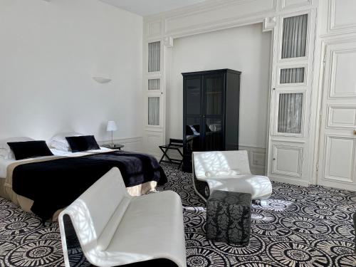 沙特尔Hôtel Particulier de Champrond的白色卧室配有床和两把白色椅子