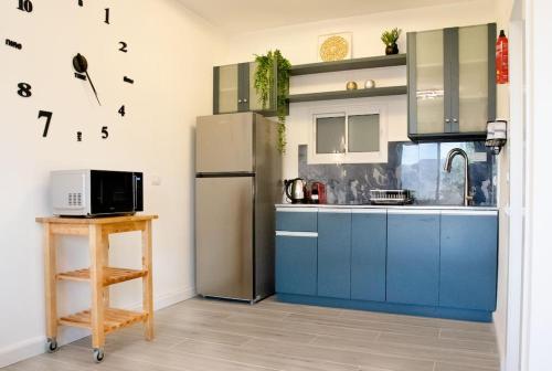 Mikhmannimהבית ליד הבוסתן的厨房配有蓝色橱柜和冰箱。