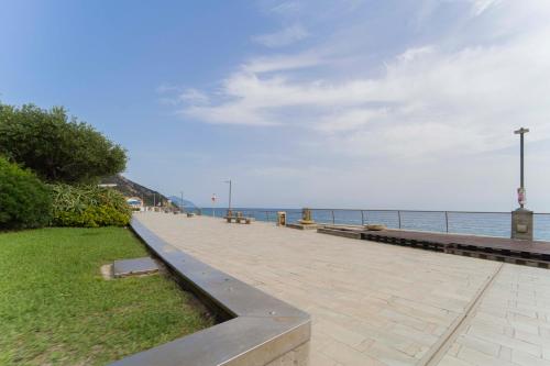 德瓦玛丽娜215 - Deiva al Mare, appartamento fronte mare con vista的海边的走道,上面有长椅