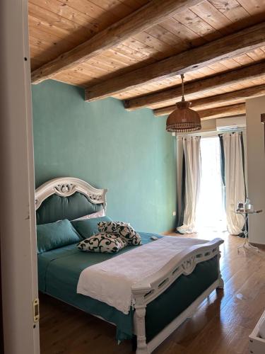 圣卢奇多B&B Casa CamiLory的一间卧室设有一张带绿色墙壁和木制天花板的床。