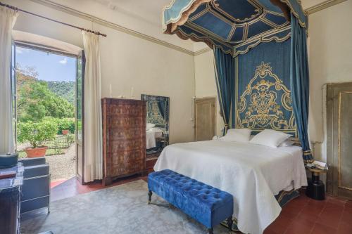 卢卡Villa Sardi Small Luxury boutique Hotel的一间卧室配有一张蓝色天蓬大床
