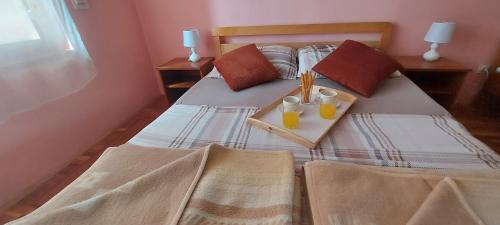 杜加雷萨Holiday house and apartments Vale的一间卧室配有一张带两杯橙汁的床