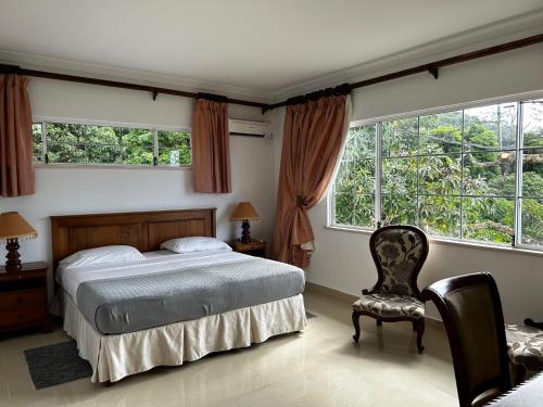 维多利亚Beau Séjour Hotel的一间卧室配有一张床、一把椅子和窗户。