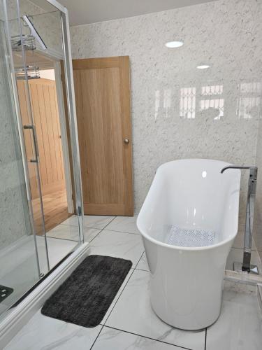 克罗默Charming 1-Bed Apartment in Cromer Town Centre的白色的浴室设有浴缸和淋浴。