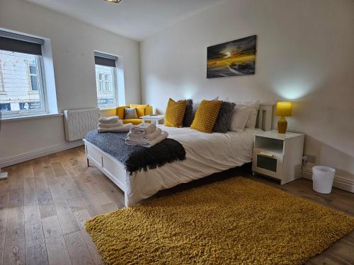 克罗默Charming 1-Bed Apartment in Cromer Town Centre的一间卧室配有一张带黄色枕头和地毯的床