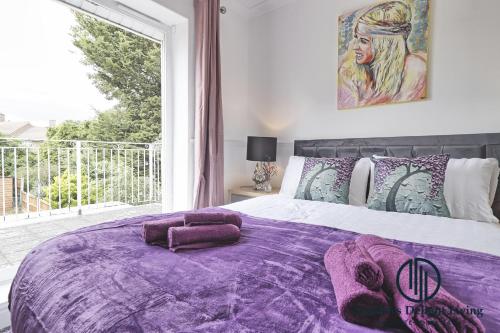 巴塞尔顿Purple Velvet - 2 Bed Home Spacious - Basildon Essex Upto 5 Guests, Free Wifi , Free Parking的一间卧室配有一张紫色床和大窗户