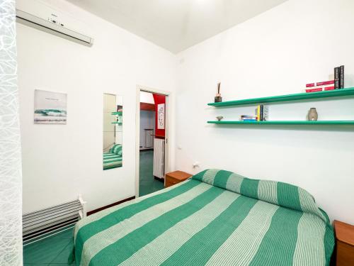 里米尼Casa Quarti的卧室配有绿色和白色条纹床