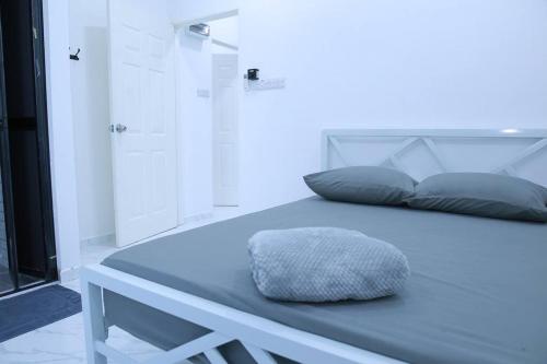 哥打巴鲁Green Dream Homestay 3 Kota Bharu 3 Aircond Room With Wifi & Netflix的一张位于带枕头的蓝色床的房间的床铺
