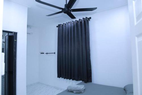 哥打巴鲁Green Dream Homestay 3 Kota Bharu 3 Aircond Room With Wifi & Netflix的配有床铺的客房内的黑色吊扇