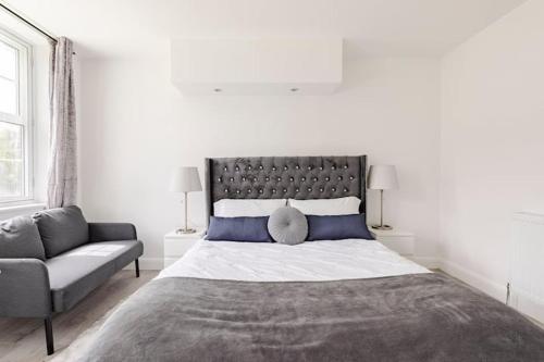 伦敦Lovely 3 bedroom flat in North London的一间卧室配有一张大床和一张沙发