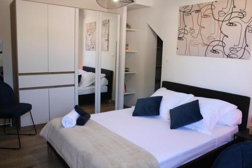 纳博讷36 2 L'air marin maison duplex grande terrasse的一间卧室配有一张带白色床单和镜子的床