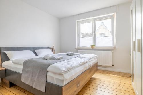霍尔茨维克德Modernes Zuhause - Küche - Top Anbindung - High WLAN的白色卧室配有一张大床和毛巾