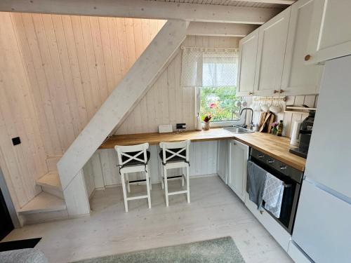 库雷萨雷Fully equipped new tiny-house的厨房中间设有两个凳子