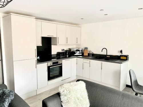 托德莫登Mill Bank Apartment的厨房配有白色橱柜和沙发。