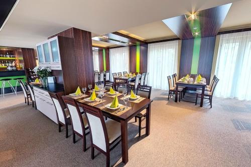 多瑙新城克鲁博酒店的用餐室配有木桌和椅子